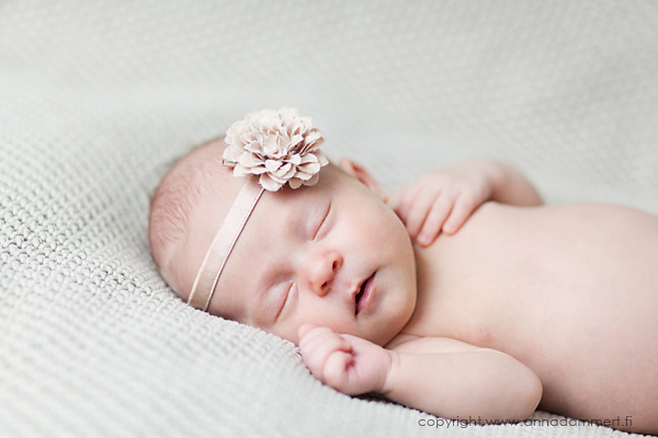 Tyttövauva nukkuu kyljellään kukkapanta päässä