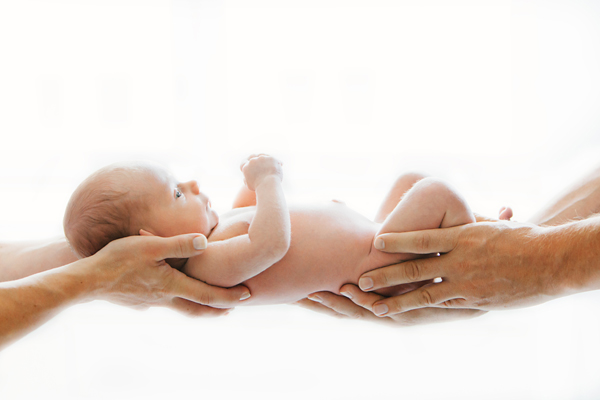 Vastasyntynyt-vauva-vanhempien-käsivarsilla-valokuvaaja-Anna-Dammert